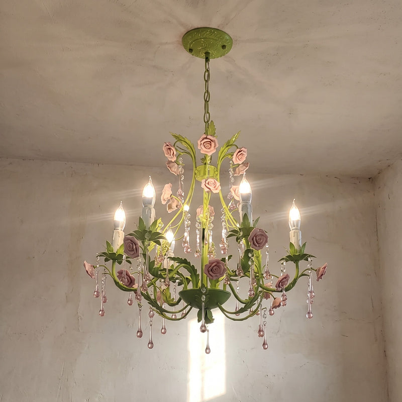 Lustre de style campagnard français suspendu, mettant en valeur sa structure métallique vert pastel et ses ornements floraux.