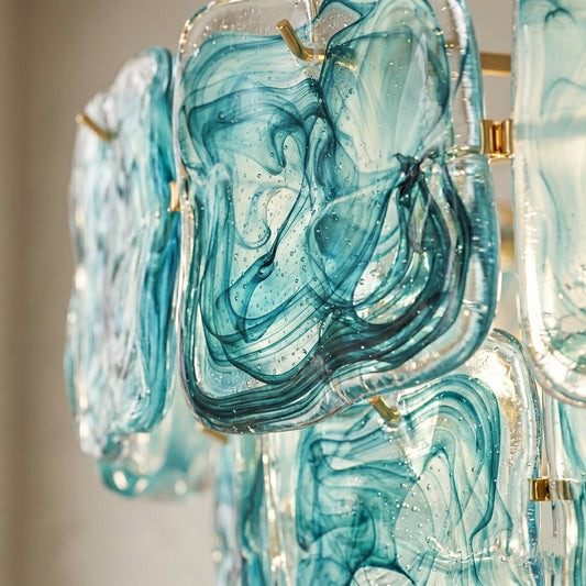 Vue rapprochée des éléments en verre teinté bleu-vert du lustre, révélant les motifs marbrés uniques inspirés de l'art vénitien.