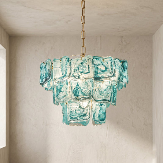Lustre suspension style Murano en verre bleu-vert marbré illuminant un salon moderne, créant une ambiance élégante et sereine.