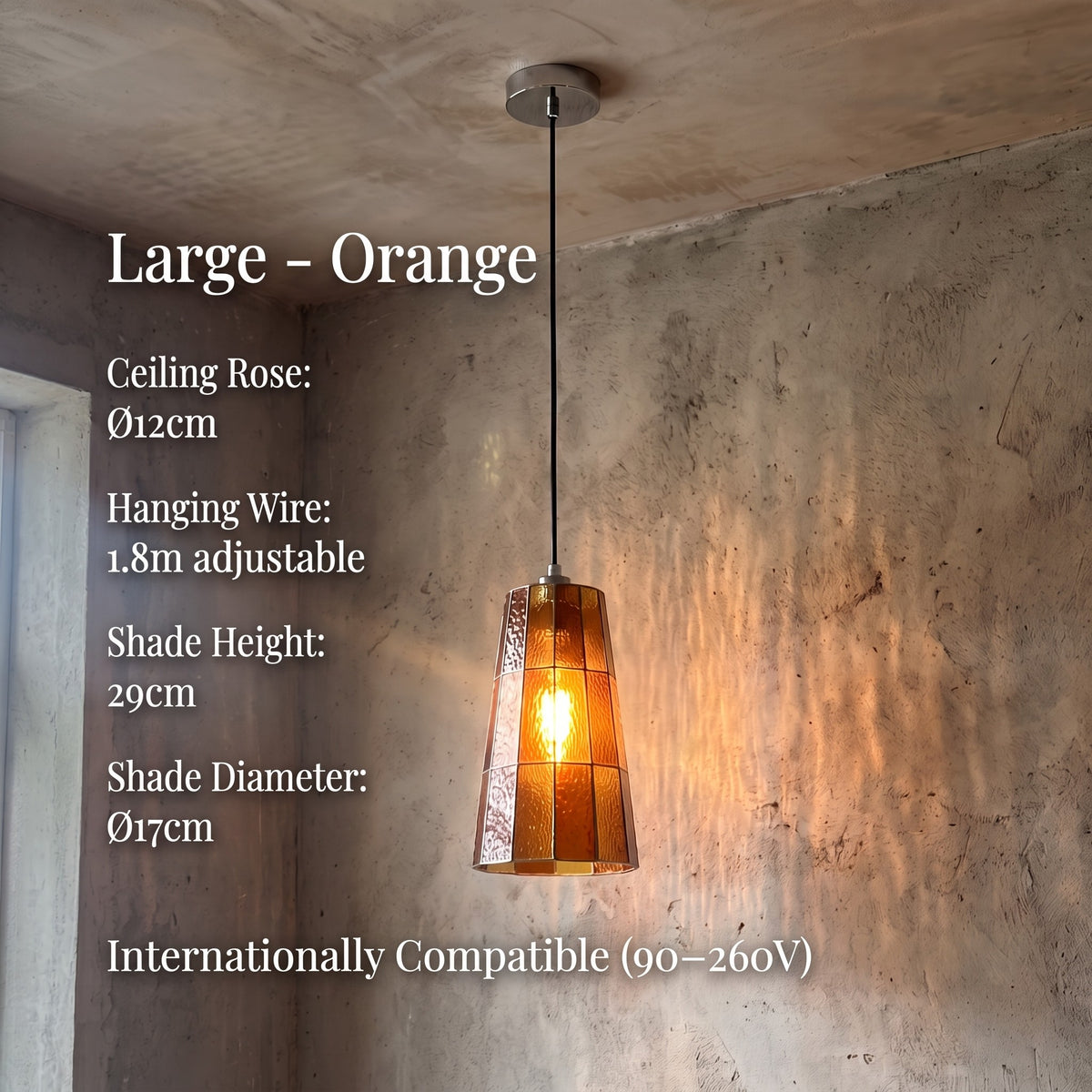 Suspension en verre teinté orange ambré installée au-dessus d'un îlot de cuisine, offrant un éclairage ciblé et stylé.