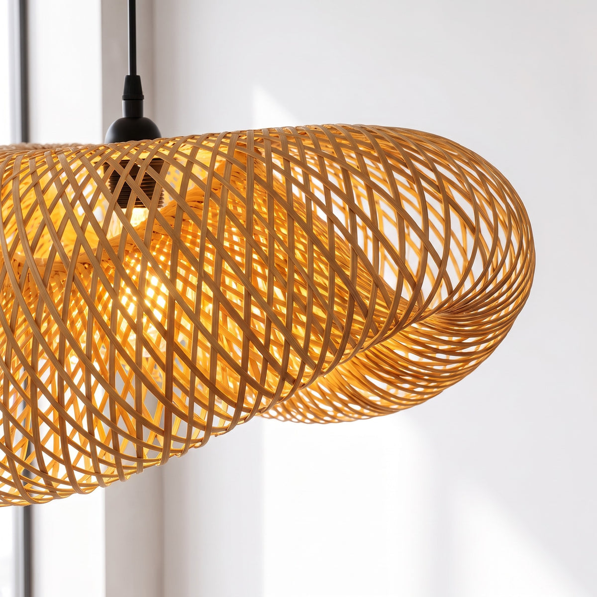 Éclairage d'ambiance avec une suspension LED en bambou tressé de grande taille, créant des jeux d'ombres uniques au plafond.