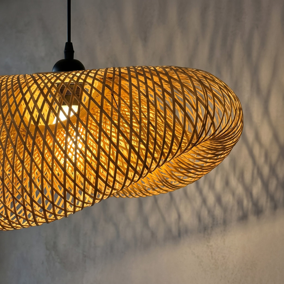 Profil de la suspension LED en bambou naturel, montrant sa forme organique et son design moderne parfait pour un salon.