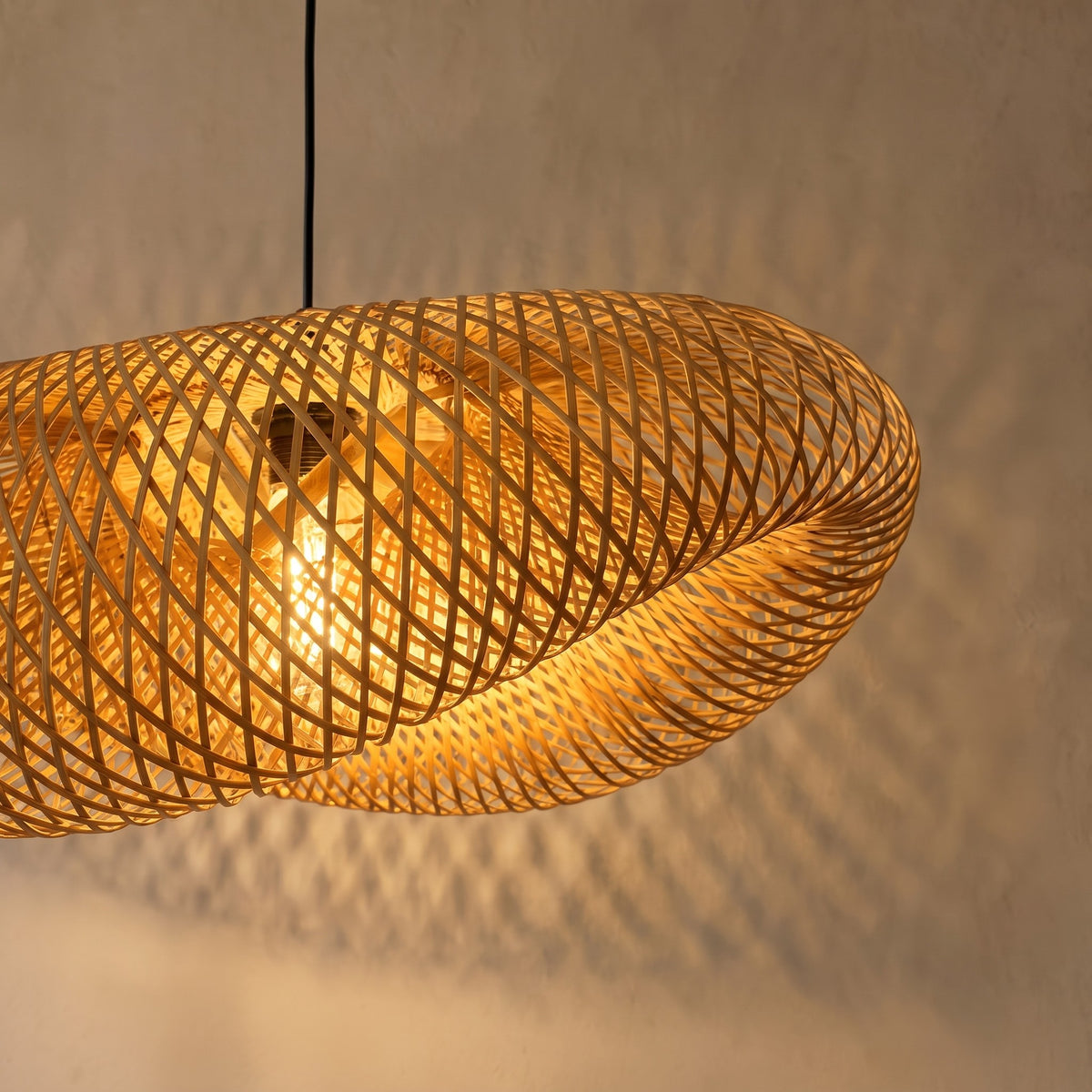 Vue d'ensemble de la suspension LED en bambou de 50 cm de diamètre, suspendue au-dessus d'une table à manger en bois clair, créant une ambiance zen.