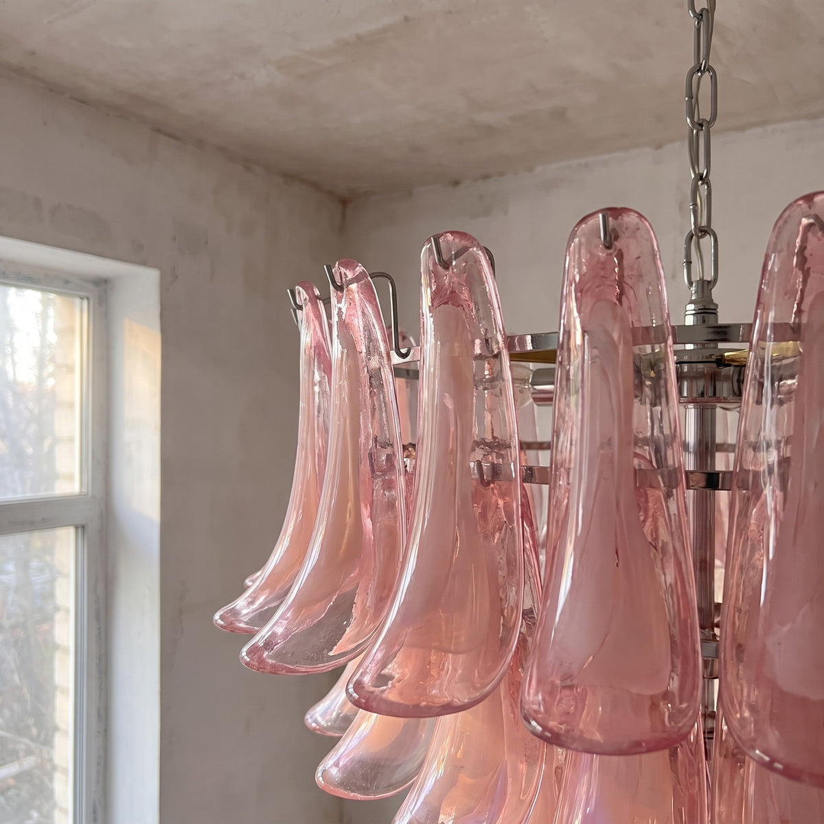 Vue latérale de la suspension lumineuse rose, mettant en valeur sa hauteur de 97 cm et l'agencement pyramidal des éléments en verre.