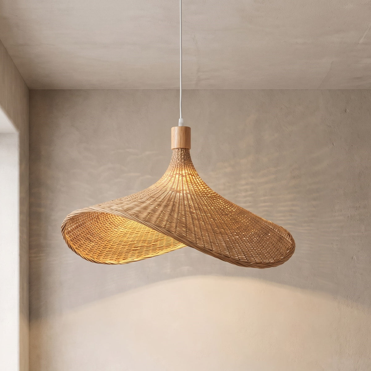 Suspension en rotin tressé naturel de 50 cm de diamètre, illuminant un intérieur avec une lumière douce et une ambiance zen, parfaite pour un salon.