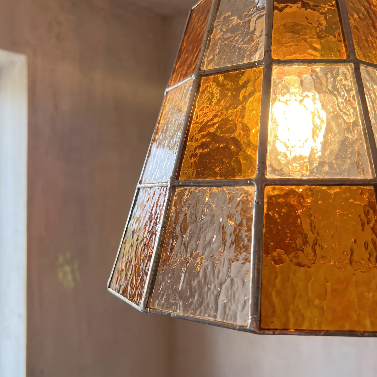 Vue latérale de la suspension en verre ambré, mettant en évidence la hauteur de l'abat-jour (14,5 cm) et le diamètre (17 cm), parfaite pour un îlot.