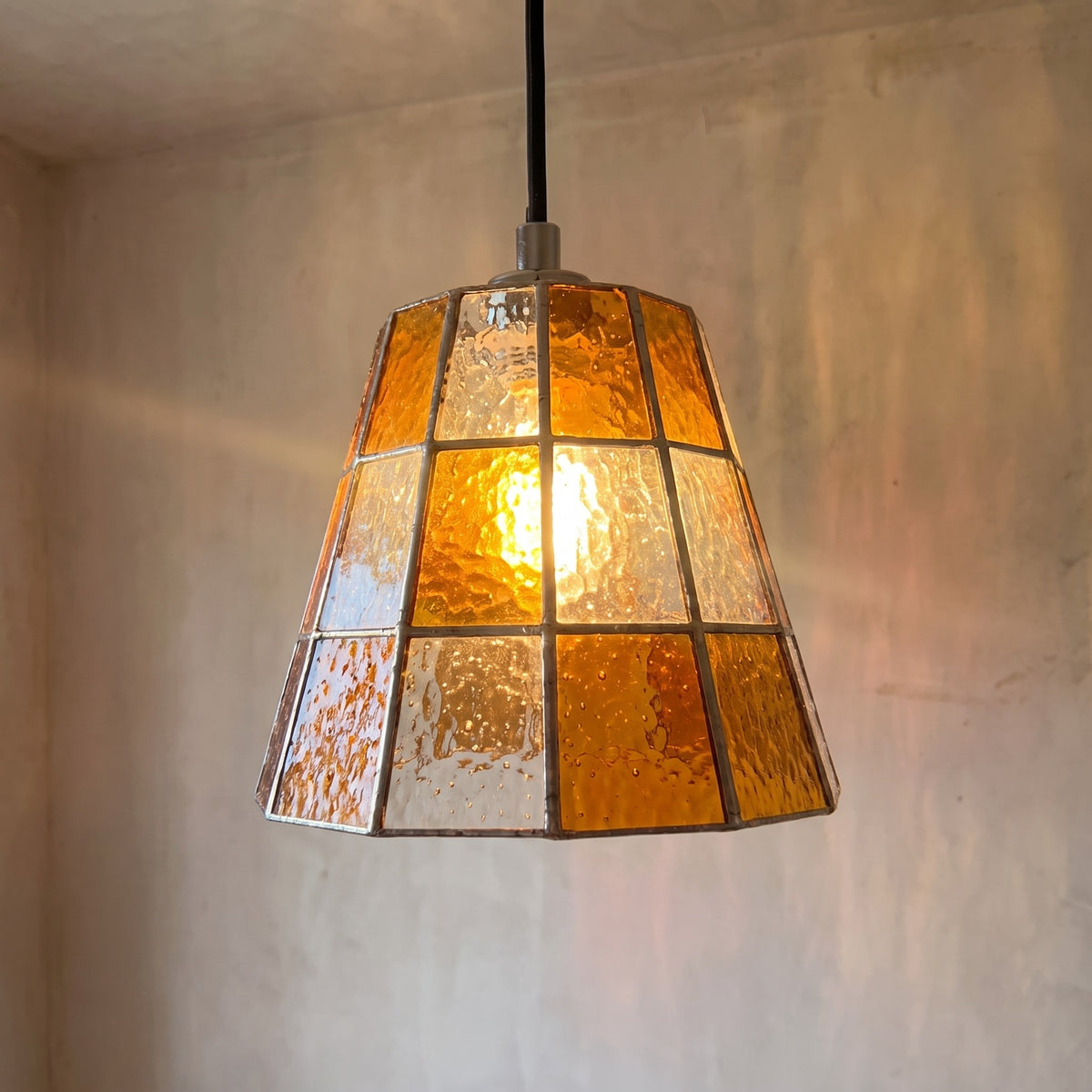 La suspension en verre ambré style Art Déco éteinte, révélant ses formes géométriques précises et son élégance intemporelle pour un intérieur raffiné.