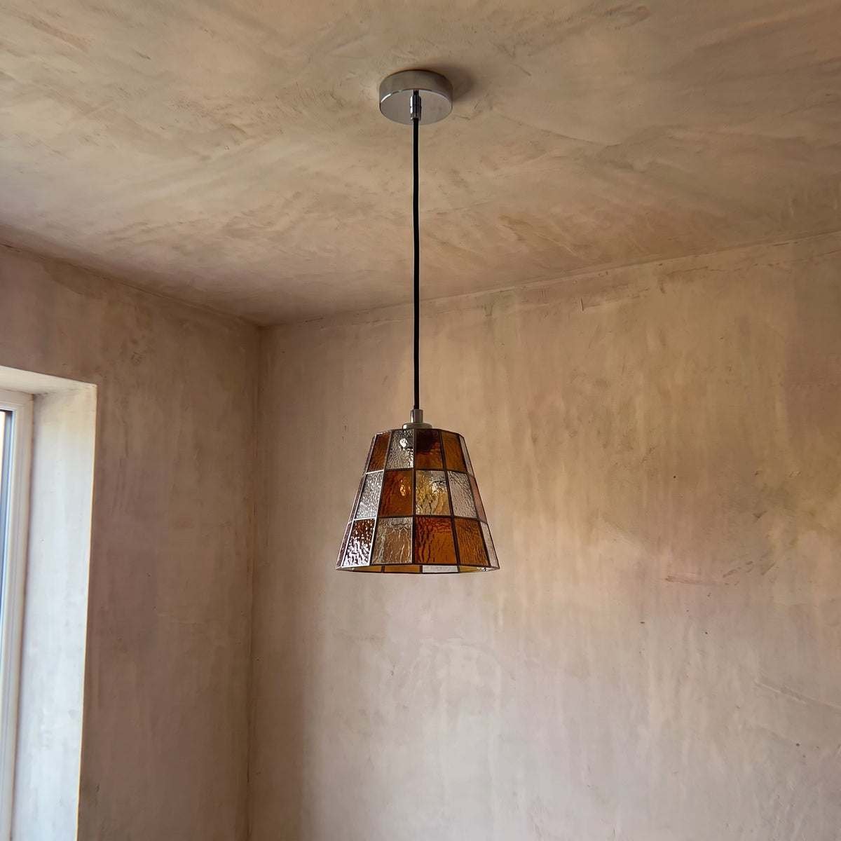 Détail rapproché des panneaux de verre teinté ambré, montrant la texture et la qualité de l'assemblage artisanal du luminaire vintage.