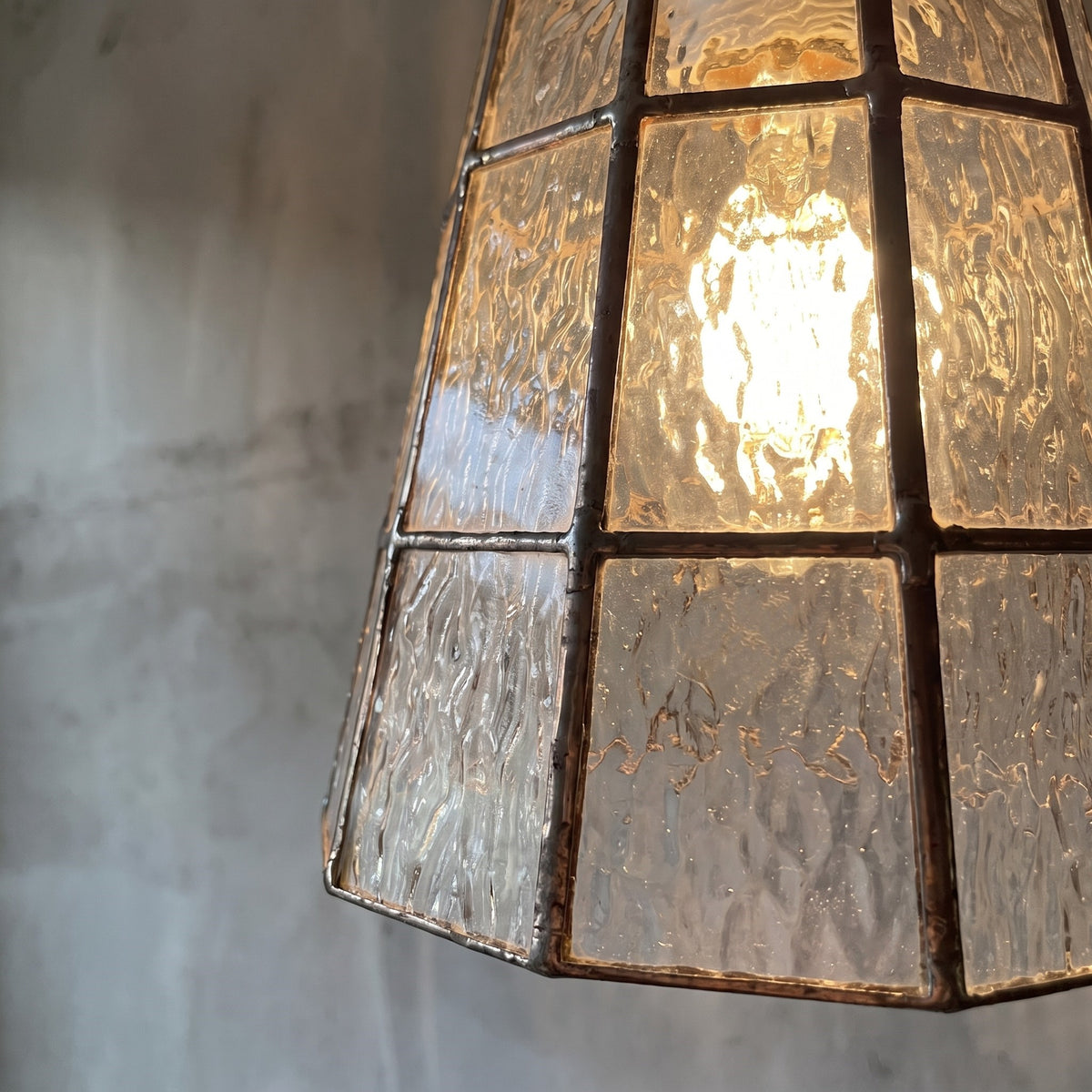 Suspension en verre texturé vue de profil, mettant en avant sa forme conique élégante et son câble réglable de 1,8 mètre.