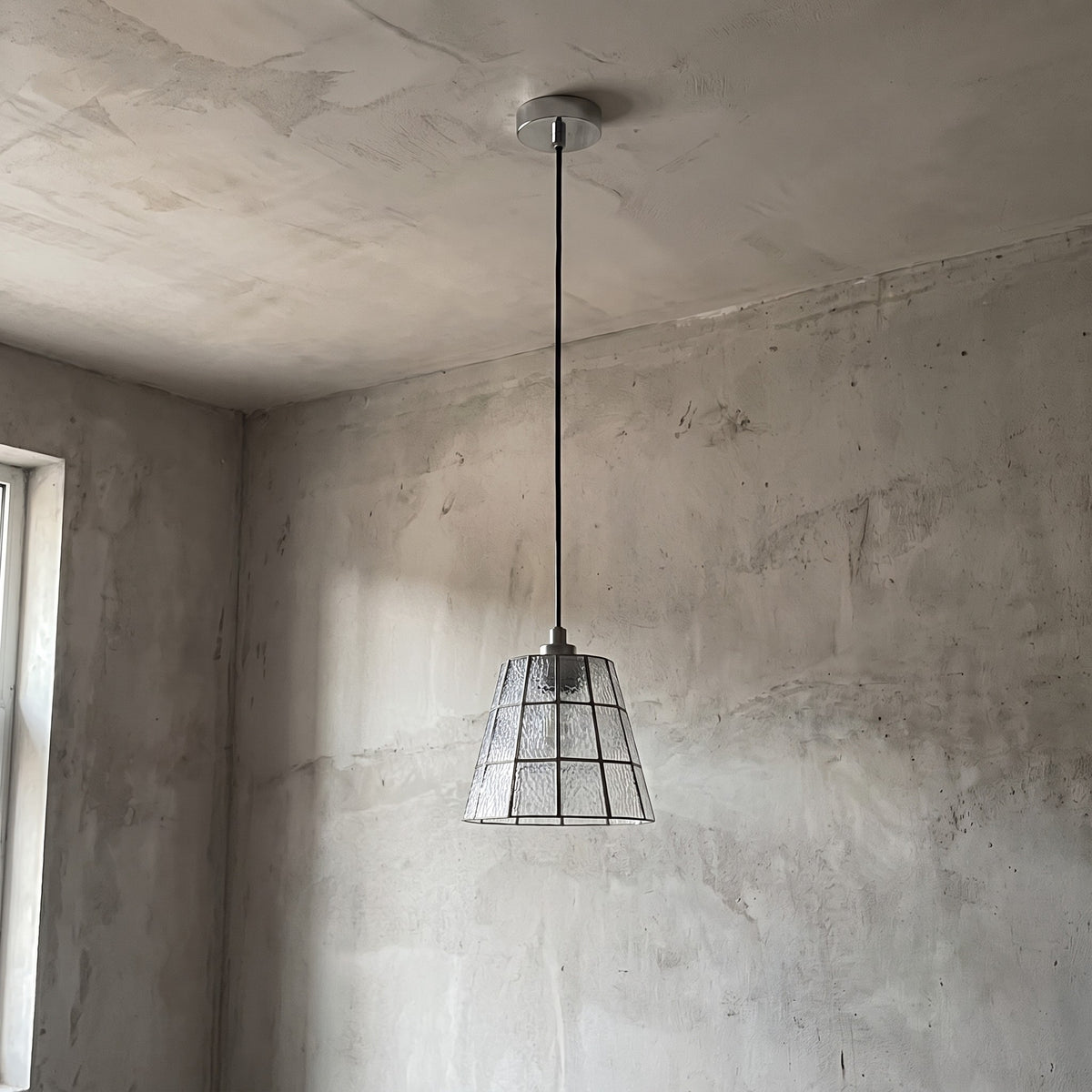 Suspension Art Déco allumée, diffusant une lumière douce et chaleureuse, créant une ambiance rétro-chic dans un salon moderne.