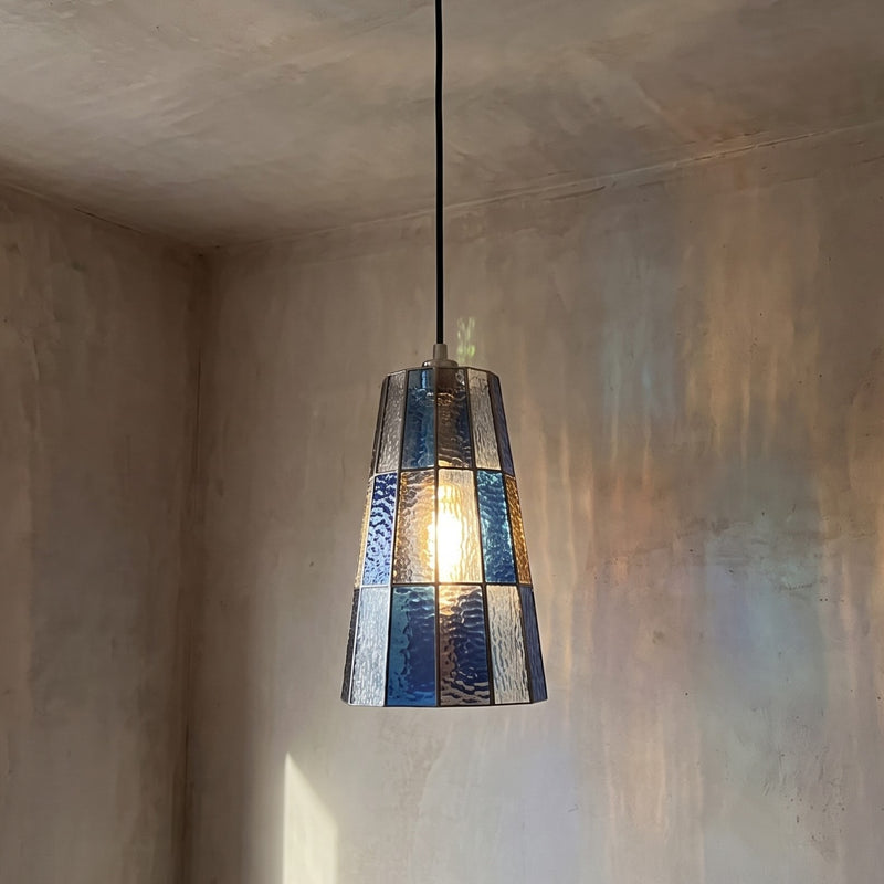 Suspension en verre teinté bleu ambré, vue d'ensemble, avec son abat-jour conique et son câble réglable.
