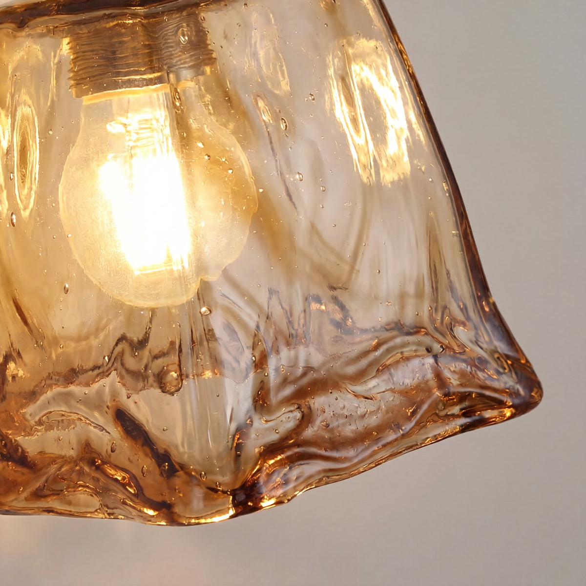 Applique murale allumée, le verre ambré diffuse une lumière douce et enveloppante. Parfait pour une ambiance Art Déco.