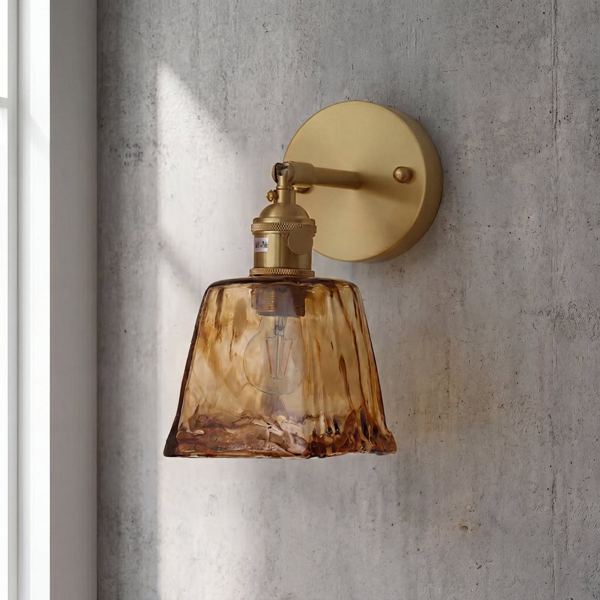 Applique murale en laiton et verre ambré installée dans un couloir. Accent lumineux discret et raffiné.