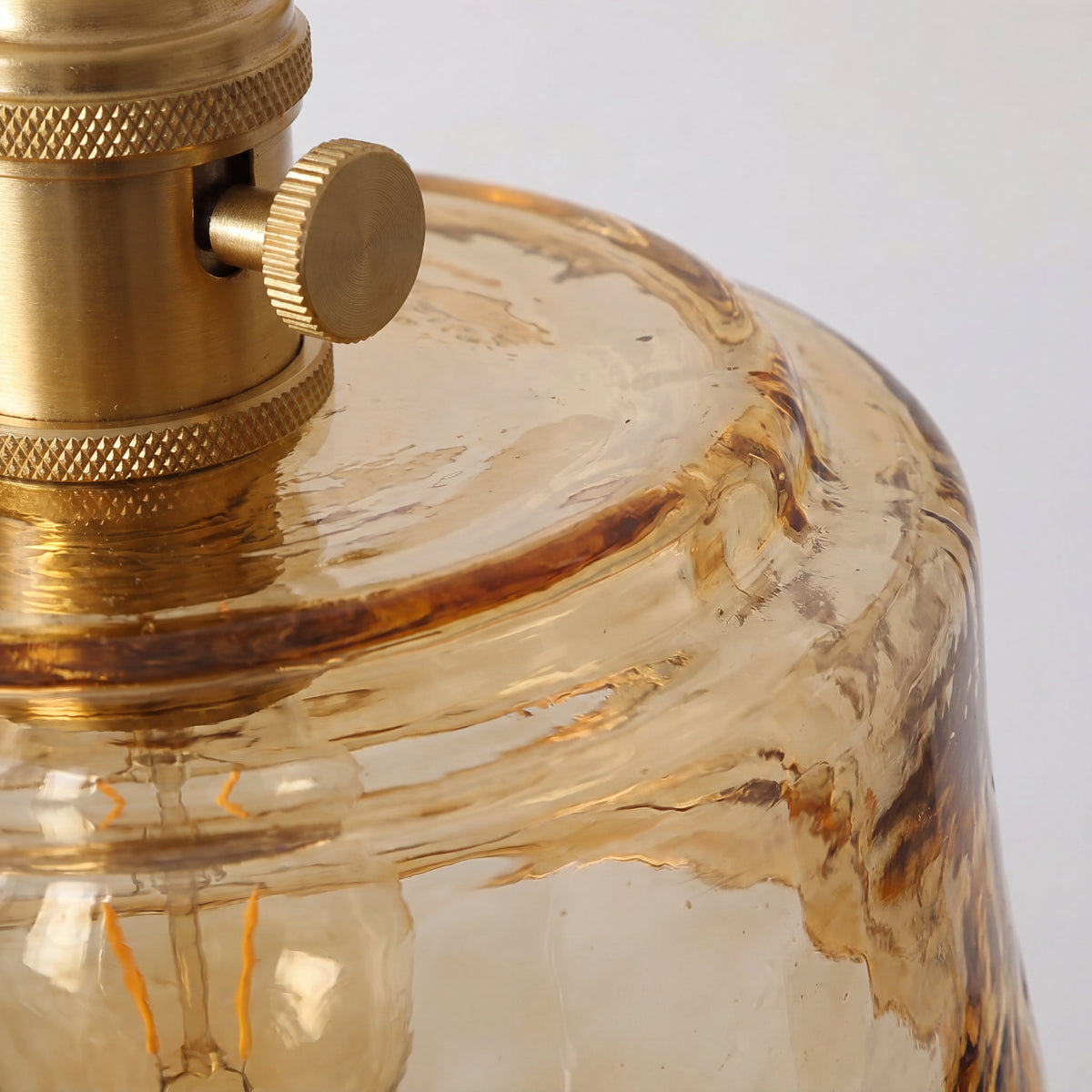 Applique murale éteinte, révélant la couleur riche du verre ambré et la finition élégante du laiton, style Art Déco.