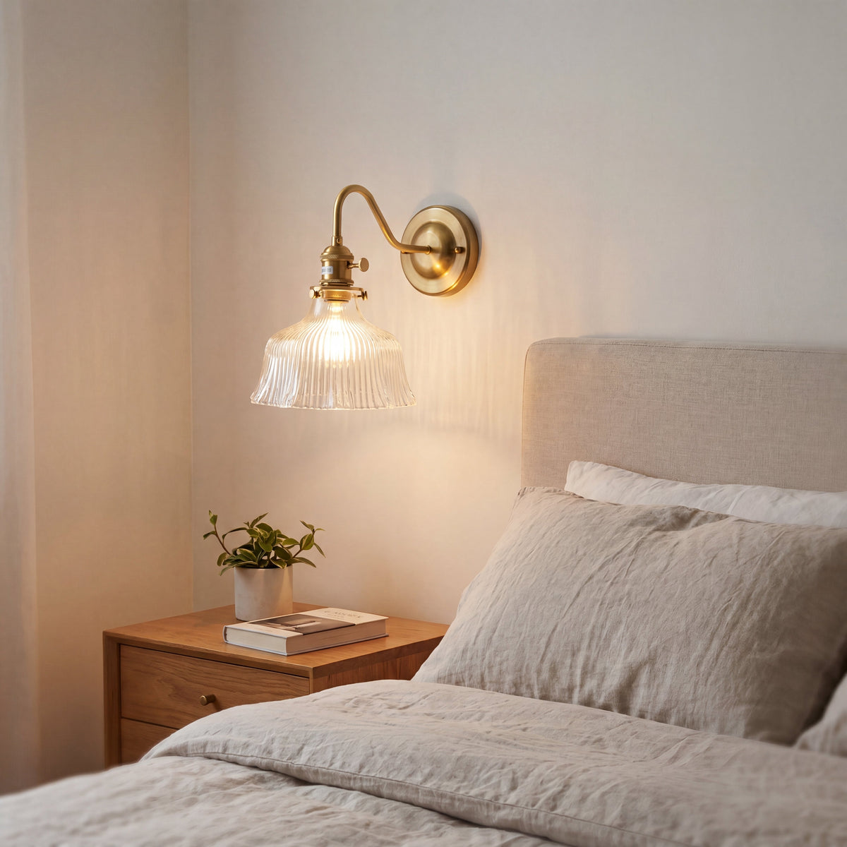 Image de l'applique style Murano allumée, projetant une lumière chaude et accueillante dans une chambre à coucher.