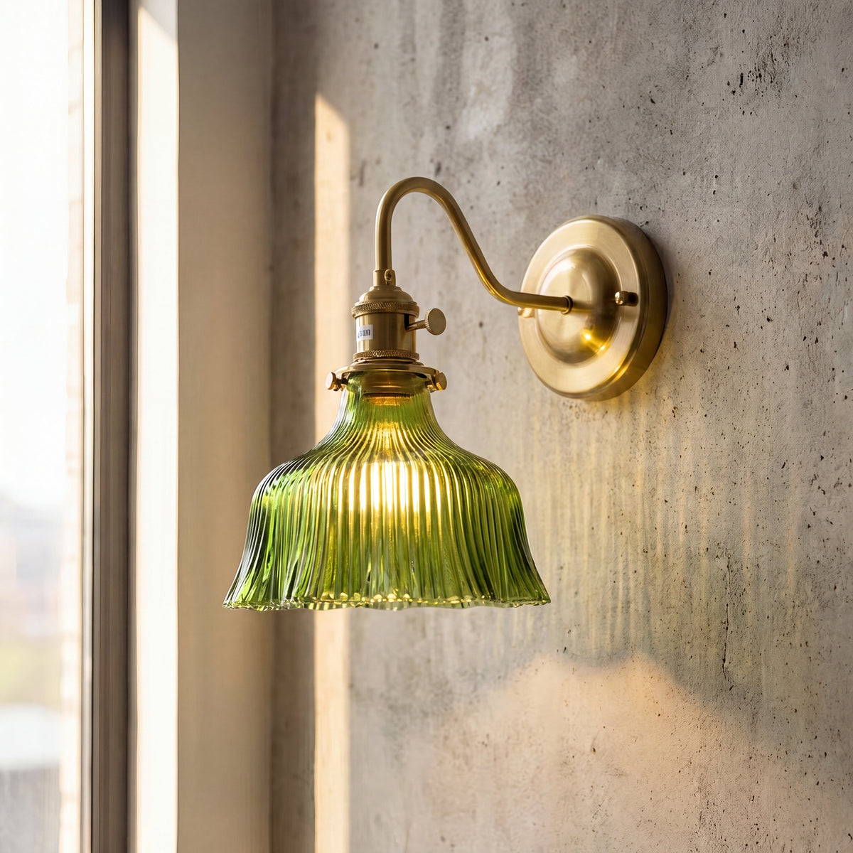 Vue d'ensemble de l'applique murale vintage en laiton et verre cannelé vert, diffusant une lumière chaude dans un intérieur classique.