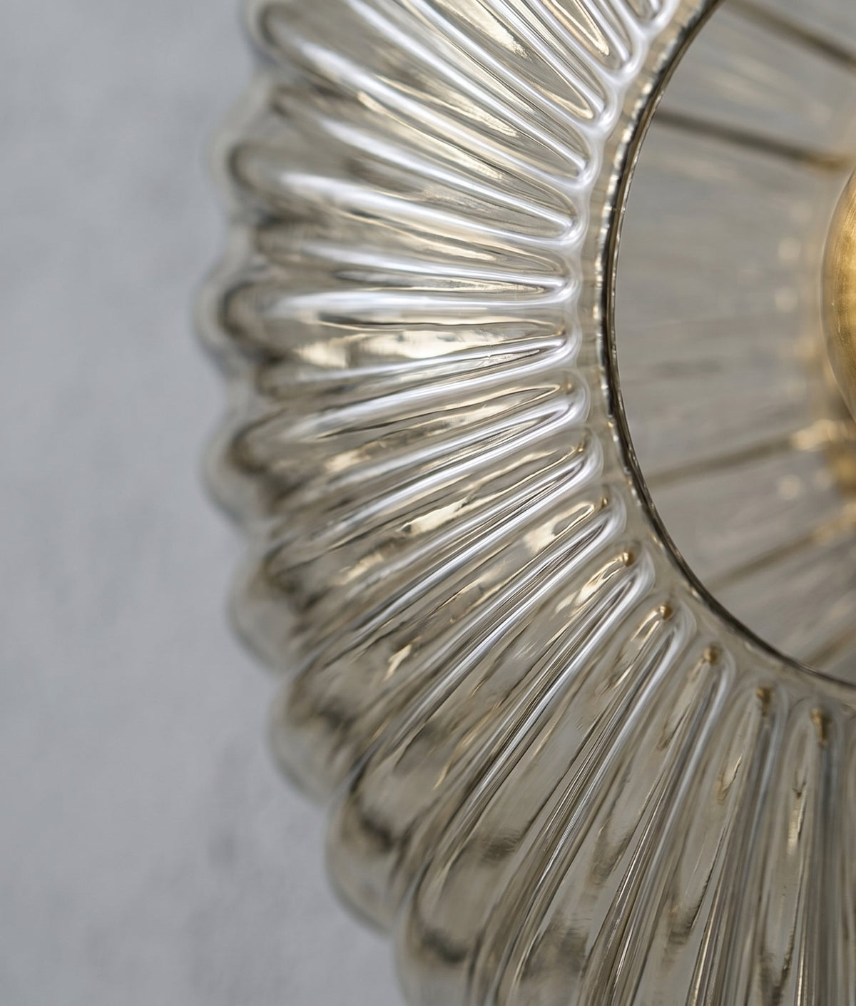 Gros plan sur la texture striée du verre cannelé de l'applique, soulignant le style Murano et la couleur gris fumé du luminaire.