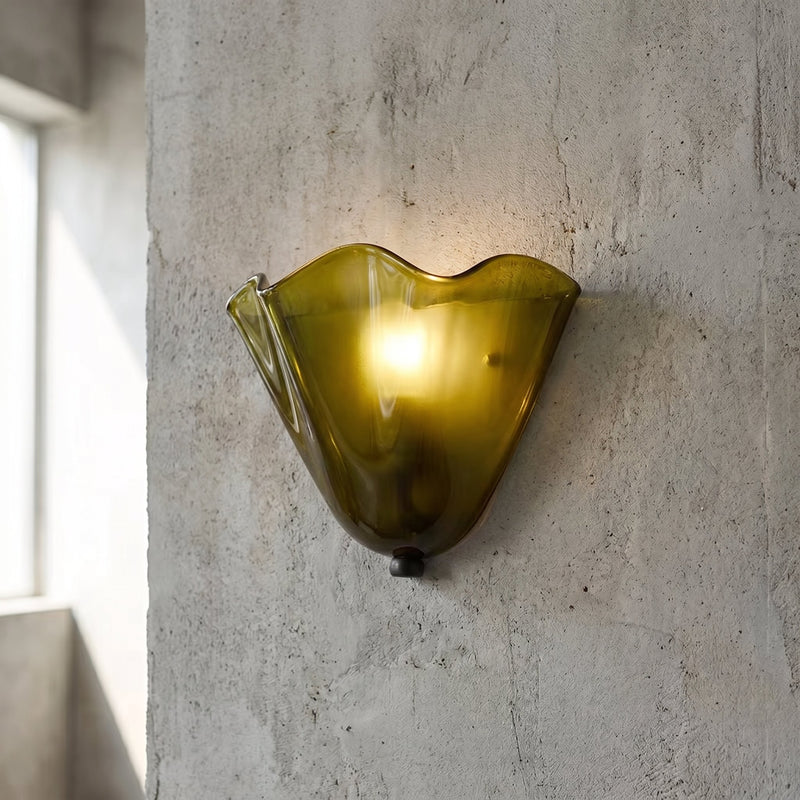 Applique murale vintage en verre ambré dégradé, installée sur un mur blanc, diffusant une lumière douce et chaleureuse dans le salon.