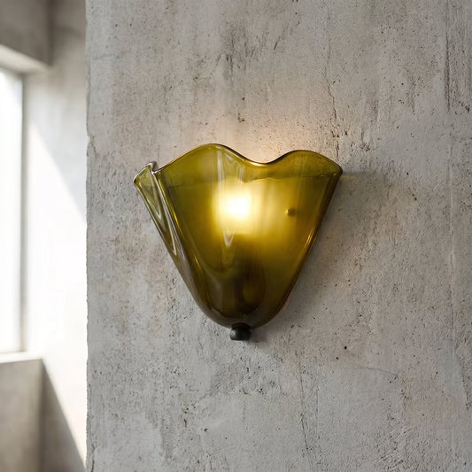 Applique murale vintage en verre ambré dégradé, installée sur un mur blanc, diffusant une lumière douce et chaleureuse dans le salon.