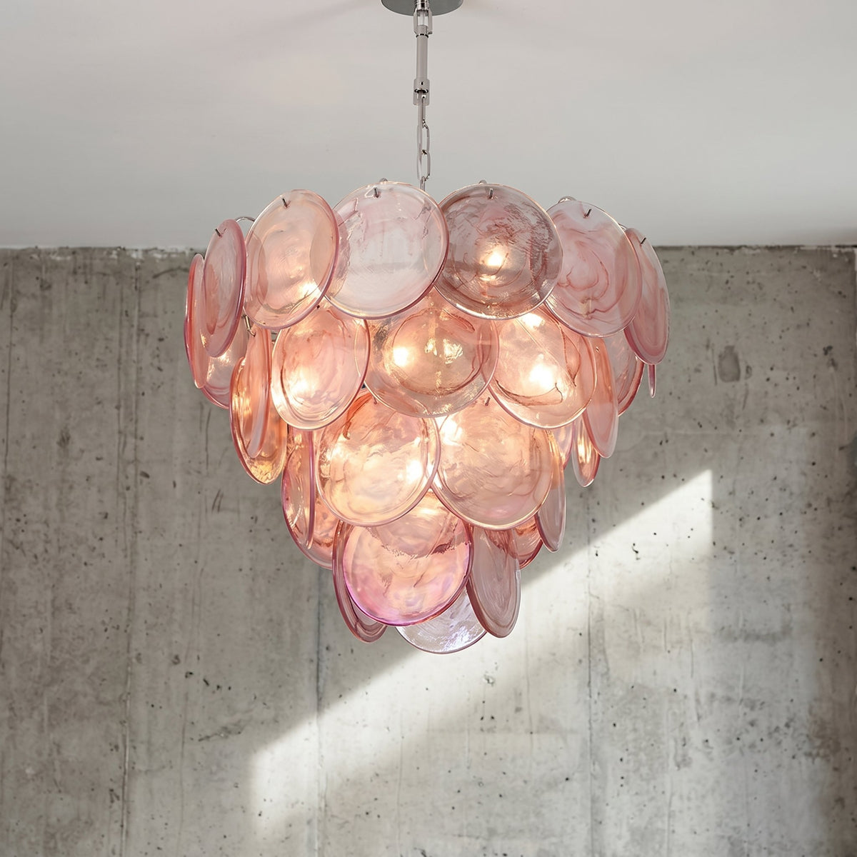 Lustre style Murano rose translucide de 60 cm de diamètre, illuminant un salon moderne avec une lumière douce et chaleureuse.