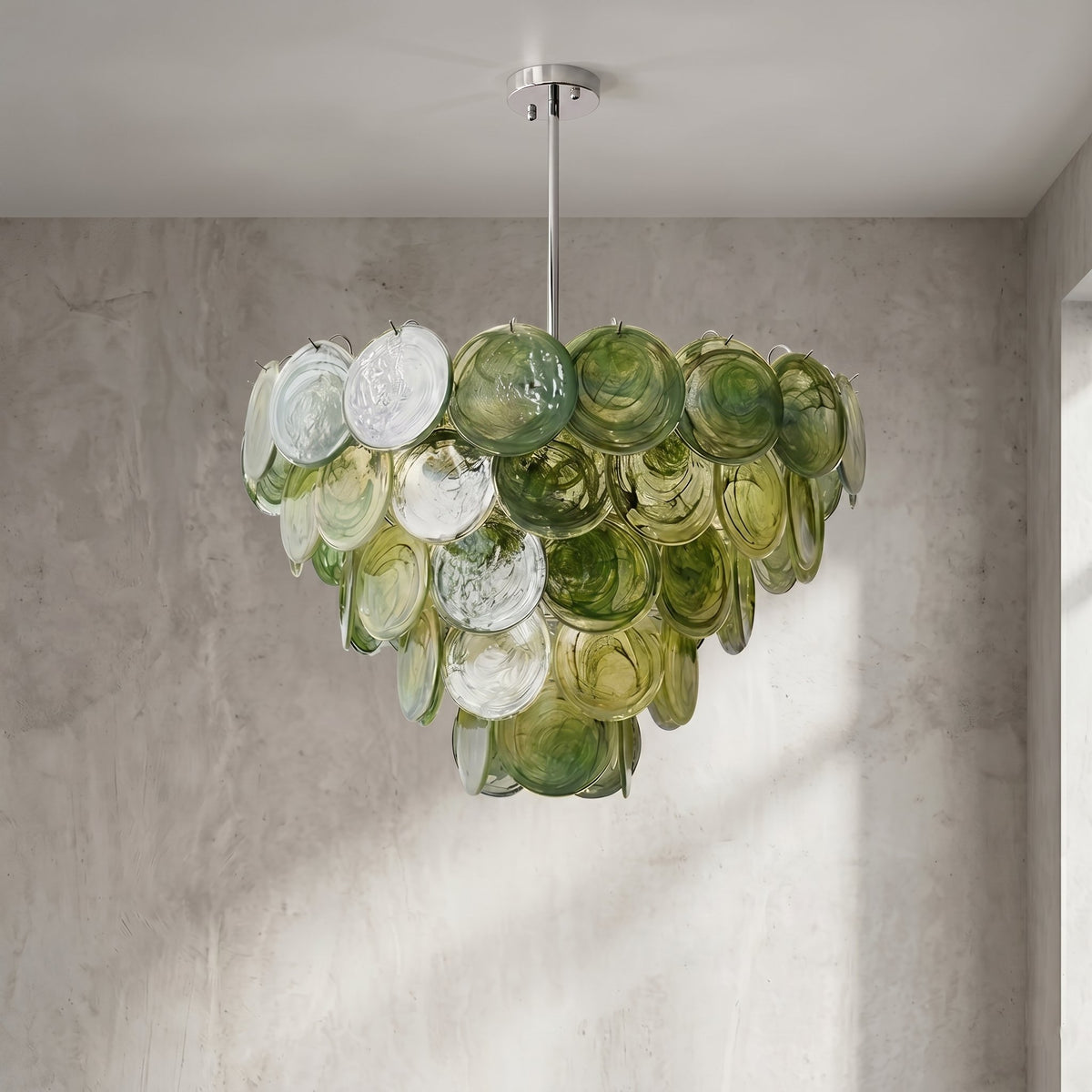 Le lustre allumé, diffusant une lumière ambiante qui met en valeur les reflets dorés et verts du verre poli.