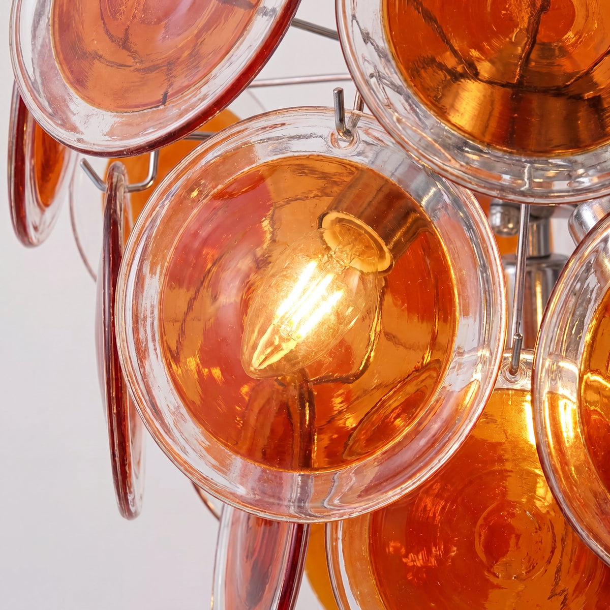 Le lustre allumé, diffusant une lumière douce et enveloppante, créant une ambiance chaleureuse et accueillante dans un salon moderne.