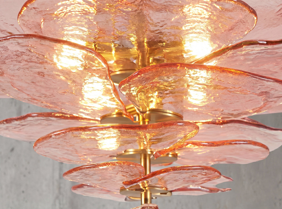 Détail des disques de verre rose poudré superposés, révélant la texture unique et l'effet lumineux délicat du lustre.