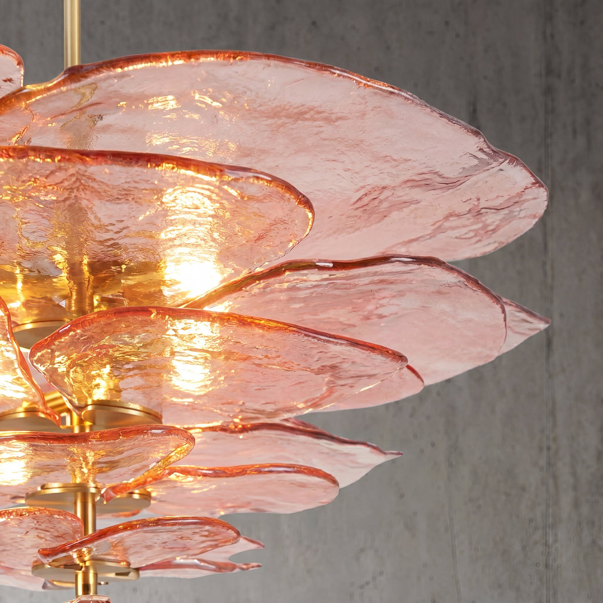 Suspension design en verre et métal, éclairée, créant une ambiance élégante dans une chambre à coucher contemporaine.