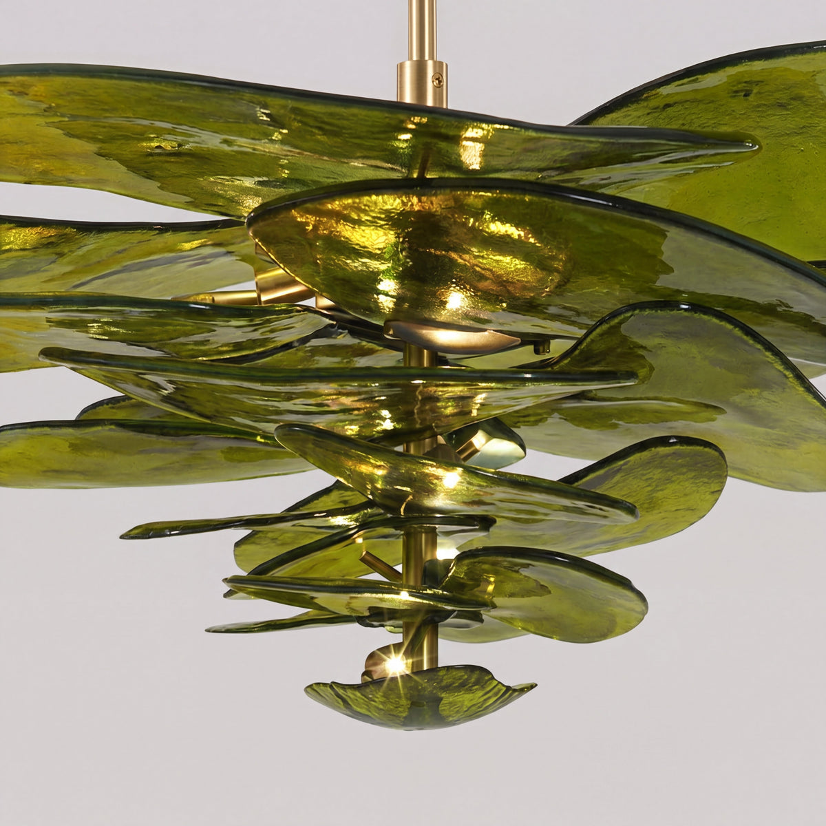 Lustre élégant en verre vert ambré suspendu au plafond, illuminant une chambre avec une lumière douce et enveloppante.