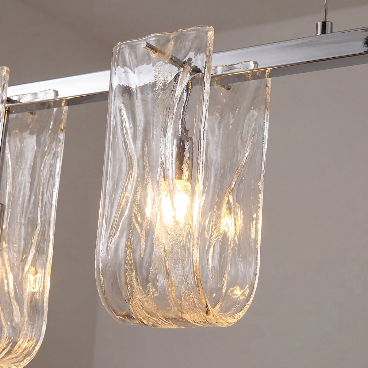 La suspension linéaire illumine une salle à manger minimaliste, mettant en valeur son design épuré et son éclairage chaleureux.
