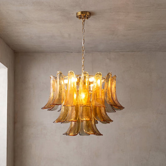 Lustre style Murano ambré avec de nombreux pétales en verre soufflé, suspendu élégamment dans un salon lumineux, créant une ambiance chaleureuse.