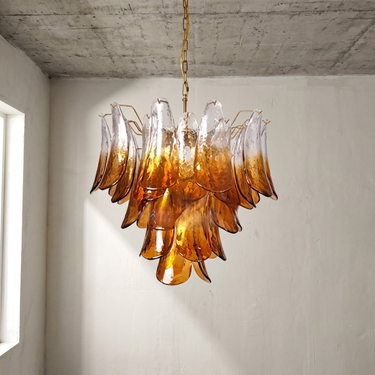 Lustre suspendu ambré style Murano en verre soufflé, apportant une lumière chaleureuse au centre d'un grand salon.