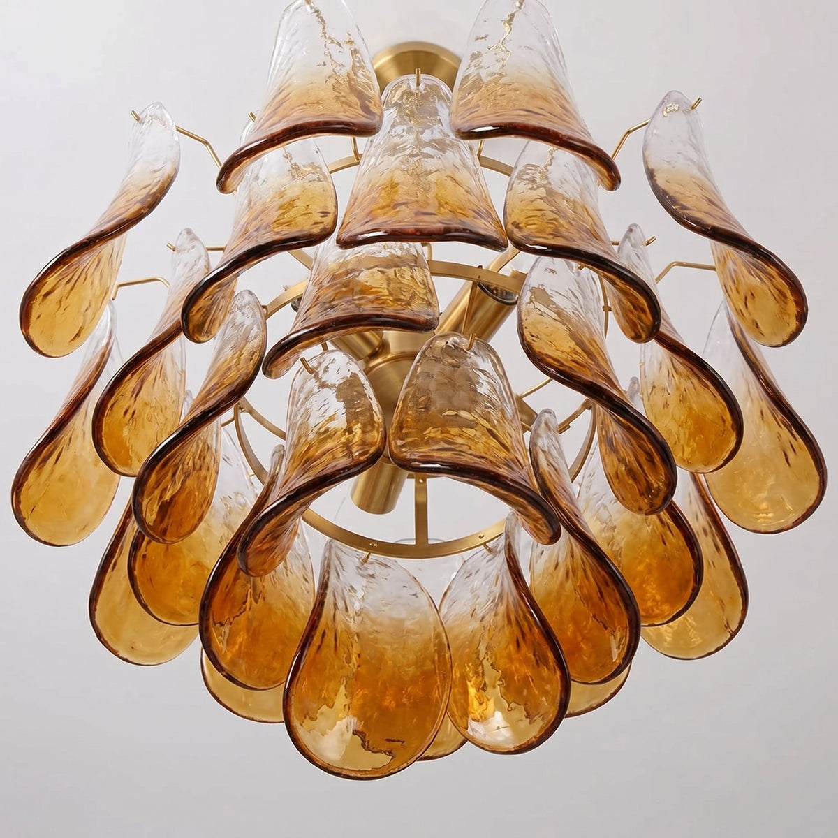 Design intemporel du lustre en verre soufflé ambré, évoquant l'art vénitien et créant une ambiance sophistiquée dans la pièce.