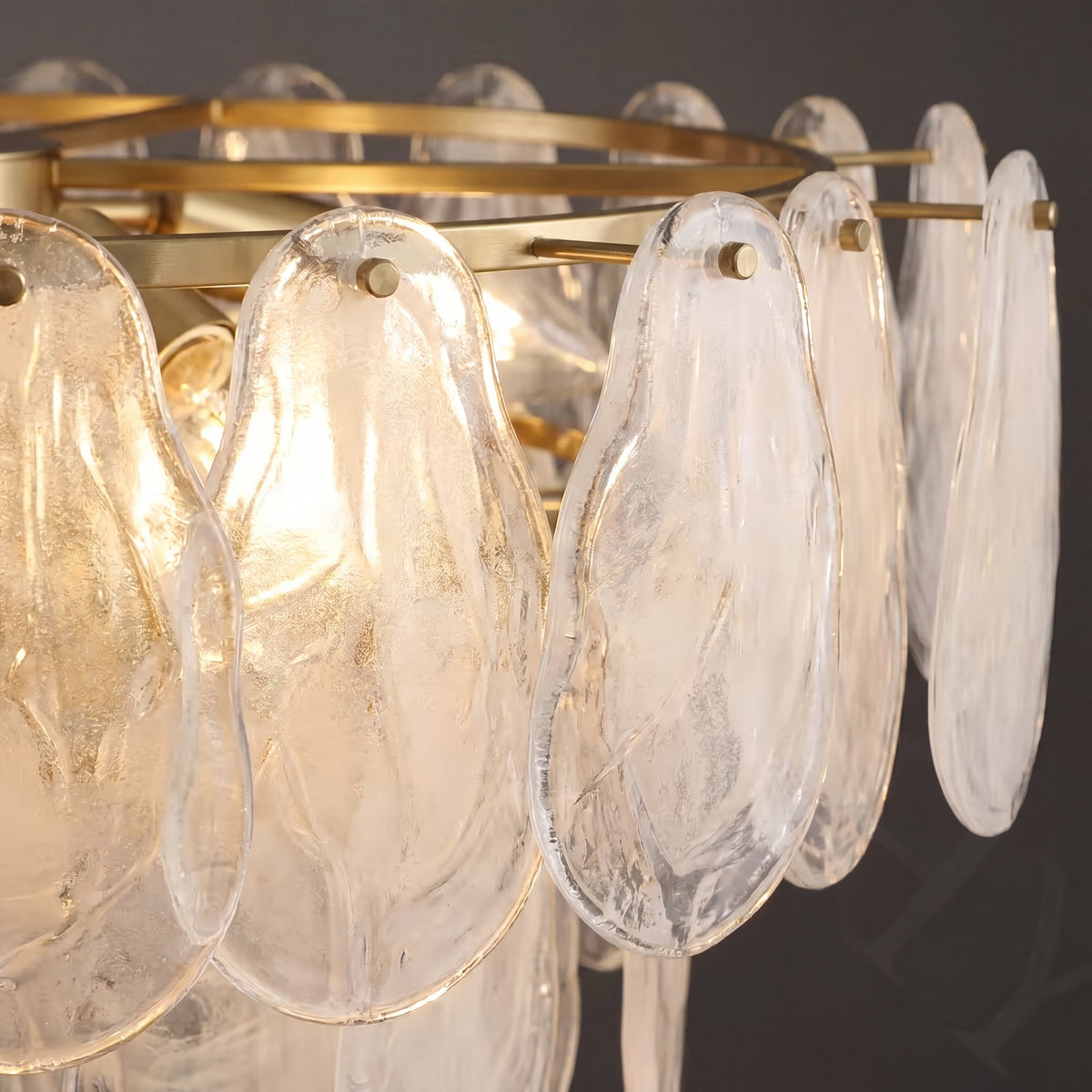 Ambiance chaleureuse créée par le lustre allumé, diffusant une lumière douce dans une salle à manger aux tons neutres et modernes.