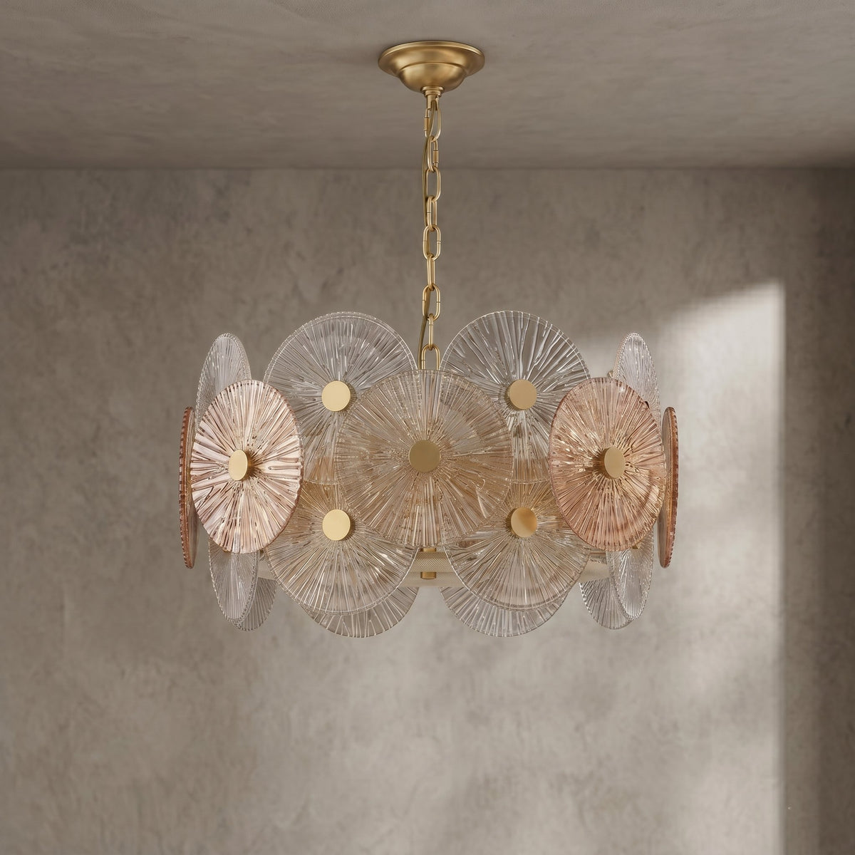 Gros plan sur les disques de verre irisés du lustre, montrant la texture délicate et les reflets chaleureux de la lumière LED.
