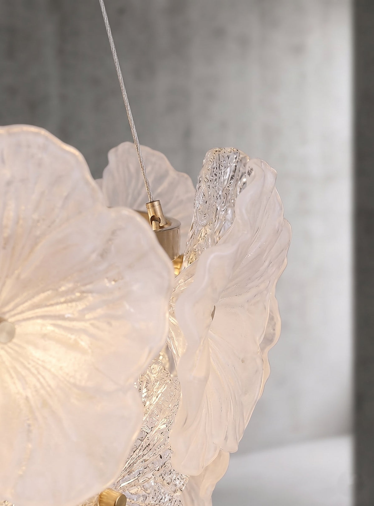Lustre moderne en forme de fleur, suspendu au plafond, créant un point focal élégant et une ambiance raffinée dans une chambre.