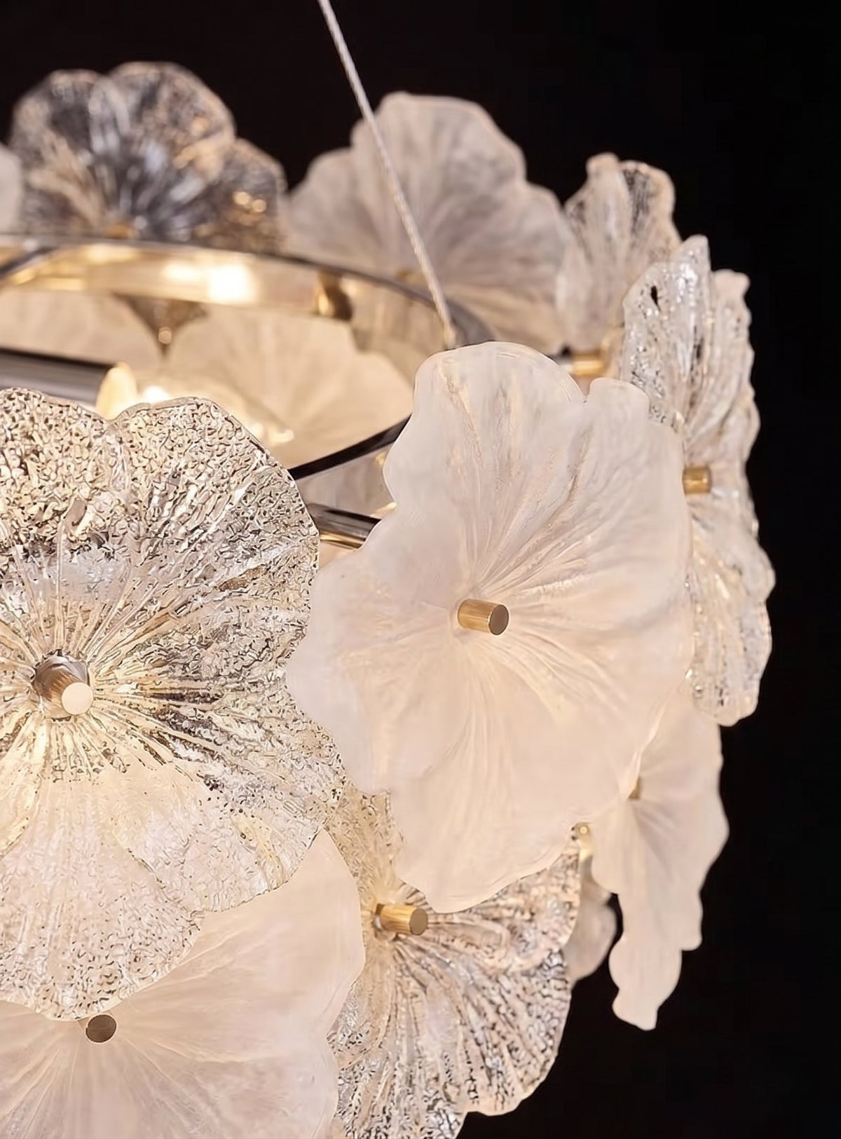 Détail de la structure en acier inoxydable poli supportant les fleurs de verre, montrant la qualité et la robustesse du luminaire.