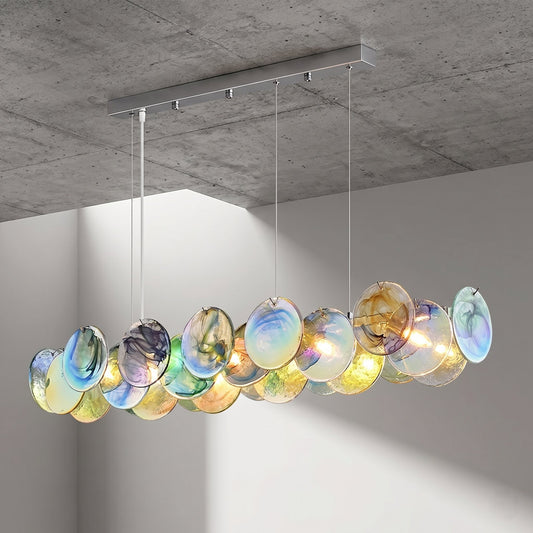 Lustre suspension allongé en verre irisé multicolore, style Murano vintage, éclairant un salon moderne avec des reflets uniques.