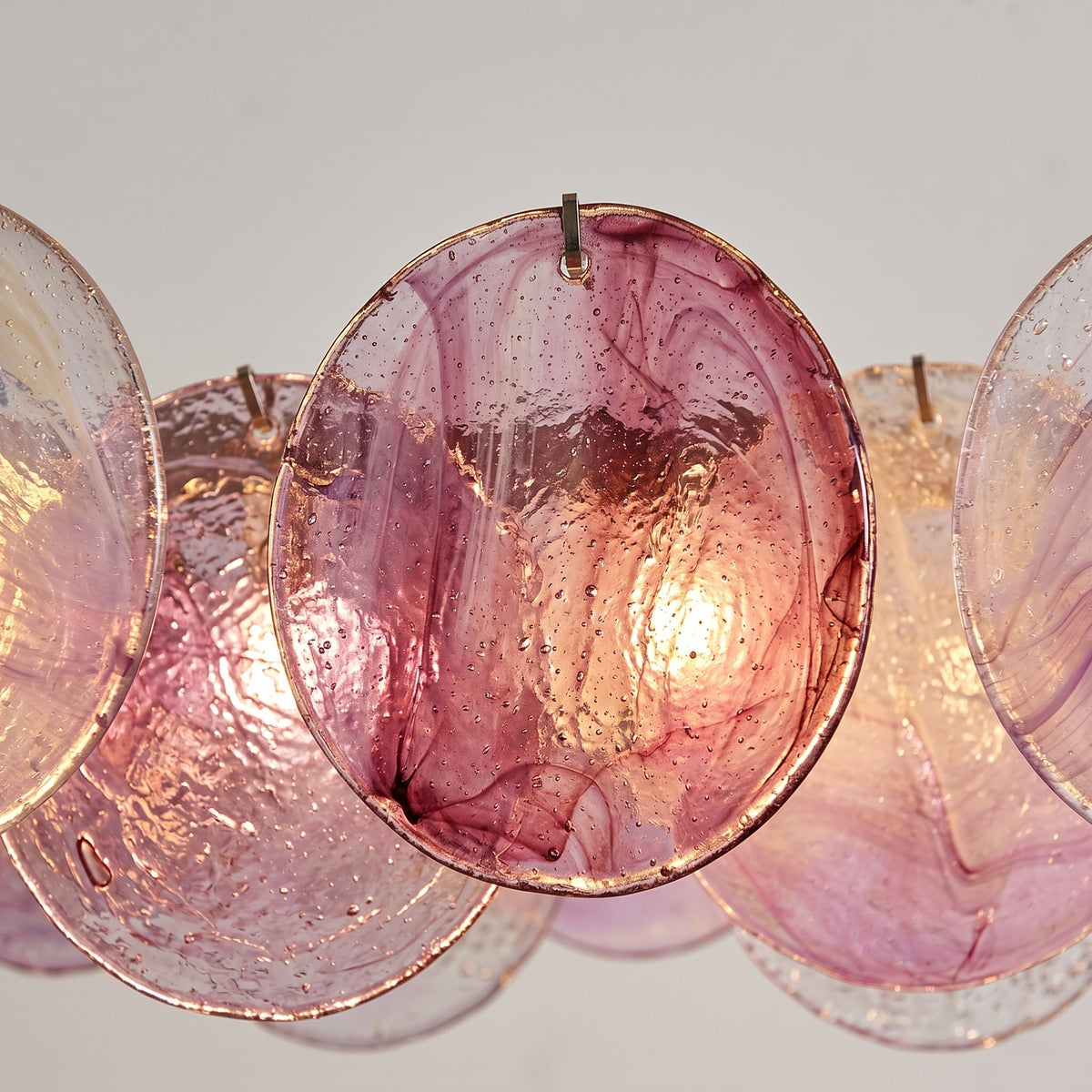 Détail de la platine de plafond en métal plaqué, supportant le lustre style Murano rose irisé avec robustesse et discrétion.