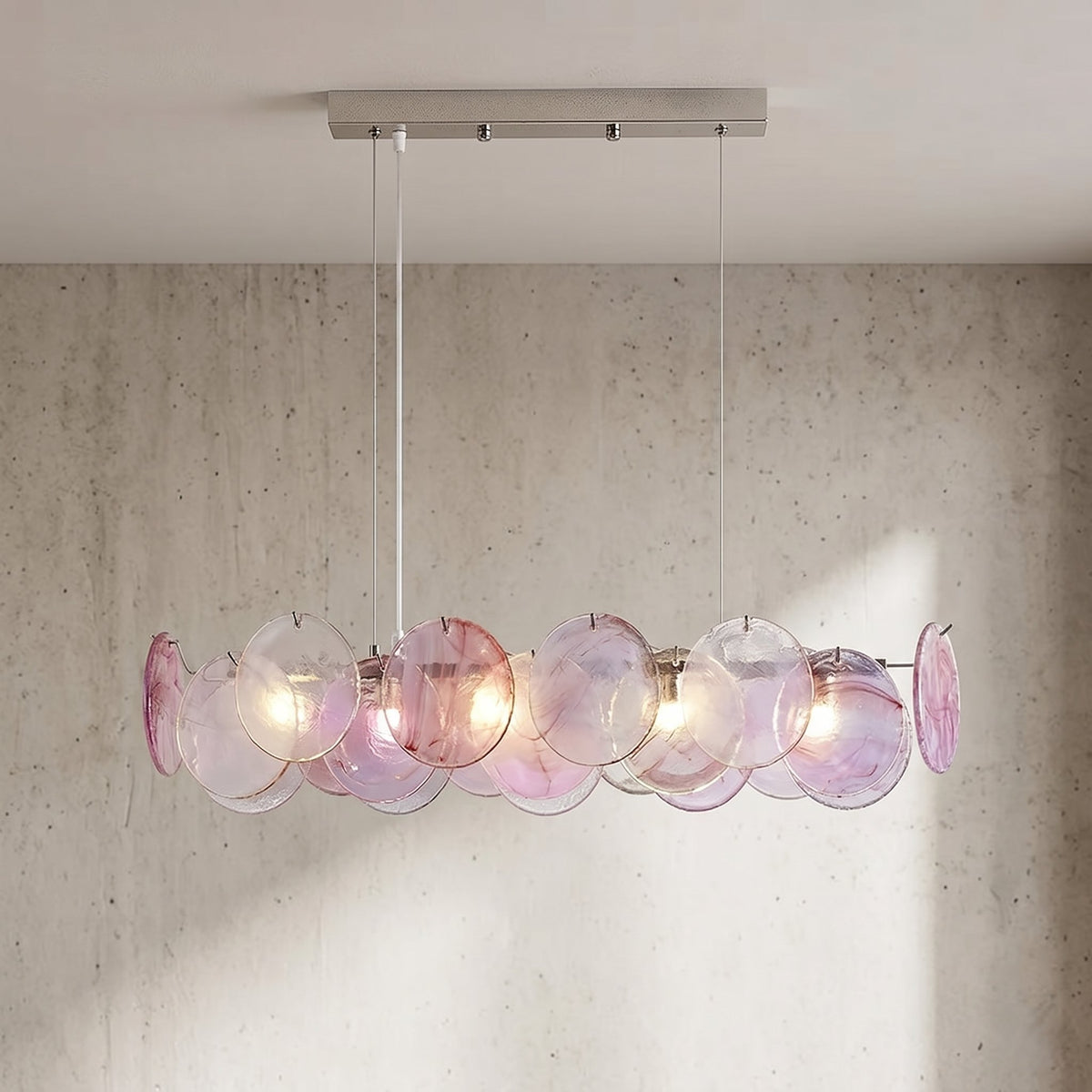 Lustre suspension rectangulaire style Murano rose irisé, illuminant un salon moderne avec élégance et reflets doux.