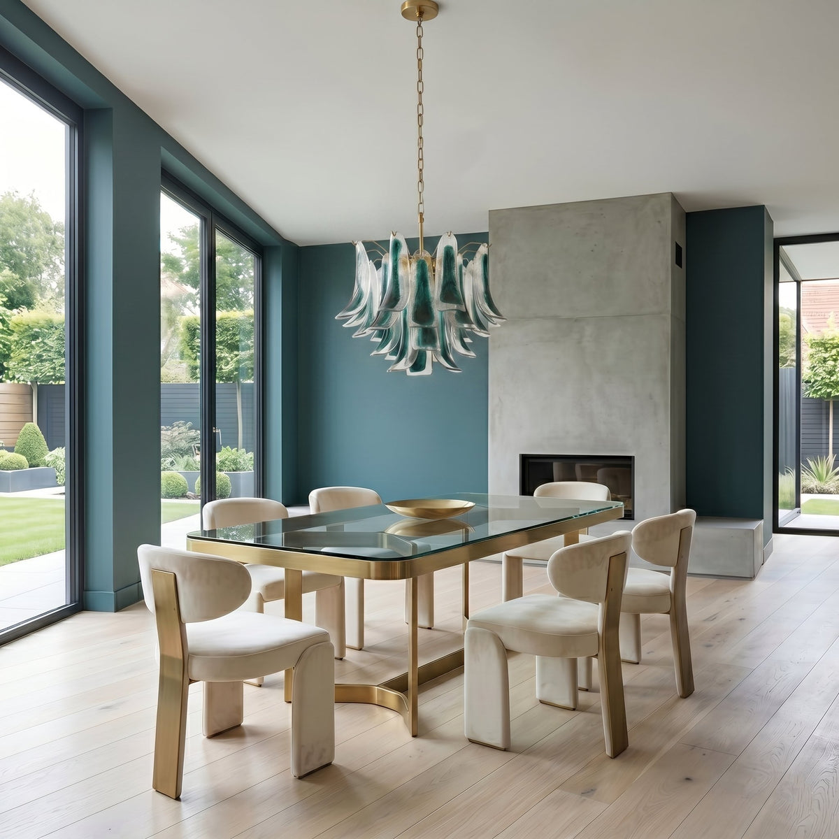 Lustre en verre artisanal vert-bleu installé dans une salle à manger, au-dessus d'une table, pour un dîner élégant.