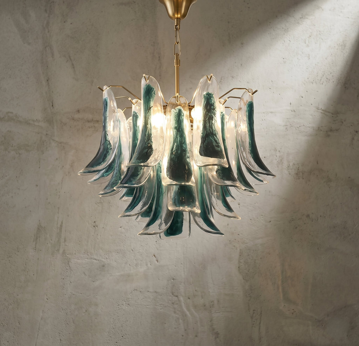 Lustre style Murano vert-bleu suspendu, éclairant un salon moderne avec une lumière douce et accueillante.