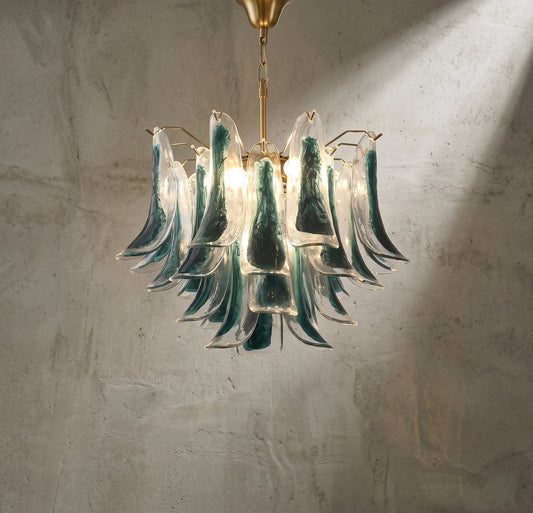 Lustre style Murano vert-bleu suspendu, éclairant un salon moderne avec une lumière douce et accueillante.
