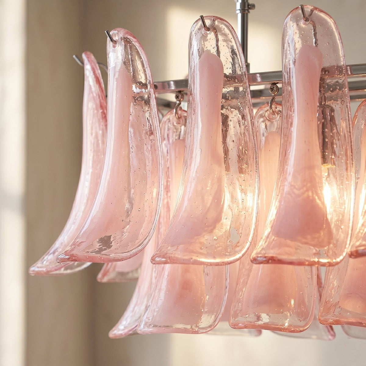 Vue rapprochée des pétales de verre rose soufflé, révélant la texture délicate et la finition artisanale du lustre Murano.