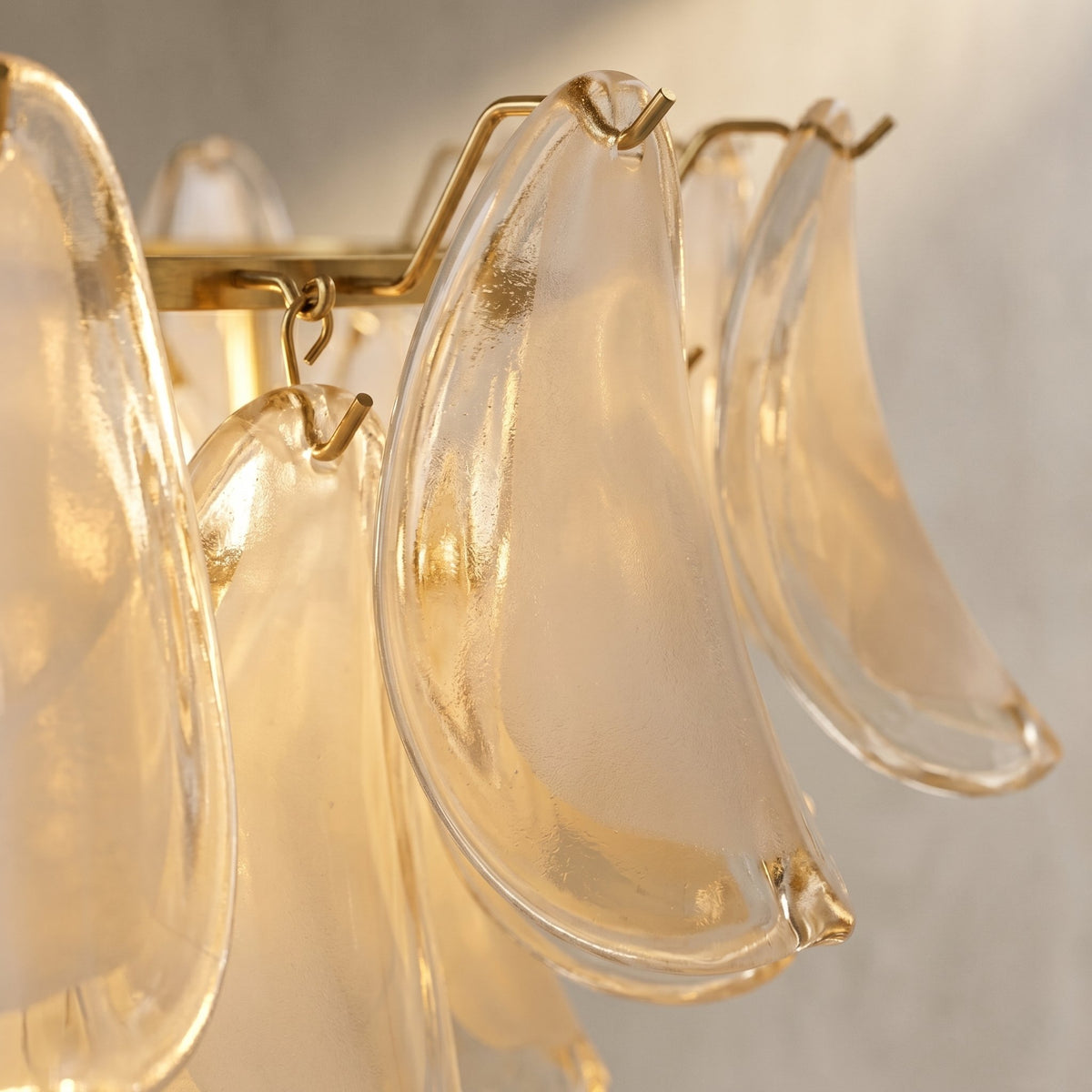 Détail du support en fer forgé doré du lustre, s'harmonisant parfaitement avec les pétales de verre blanc opalin.
