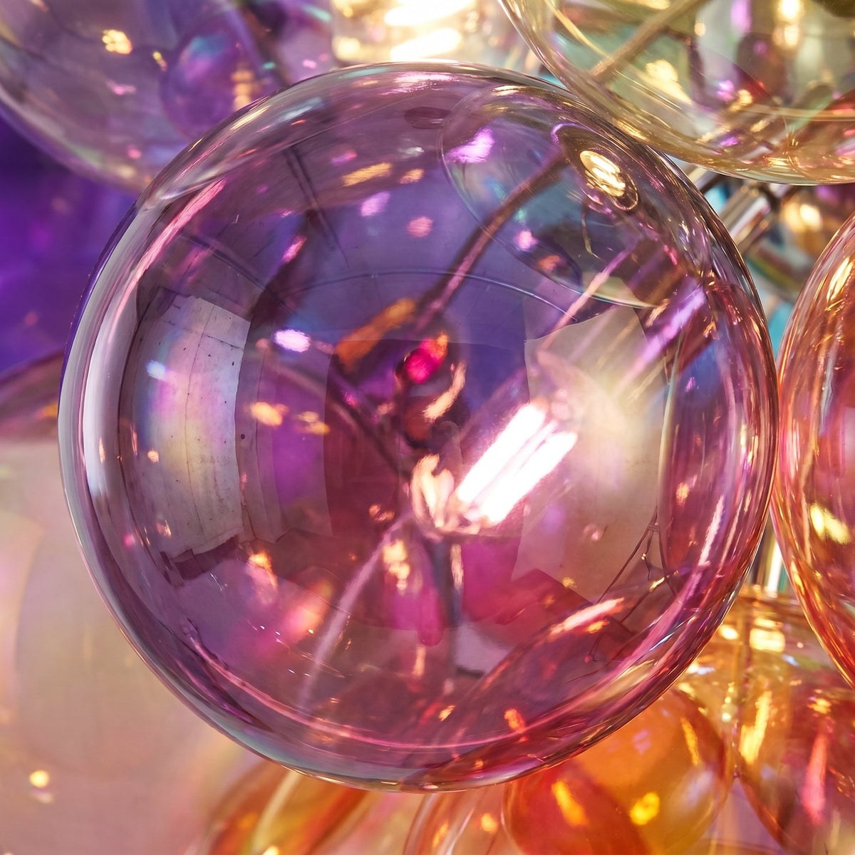 Image d'ambiance du lustre bulles de verre multicolores, créant une atmosphère chaleureuse. Le design évoque un esprit intemporel.