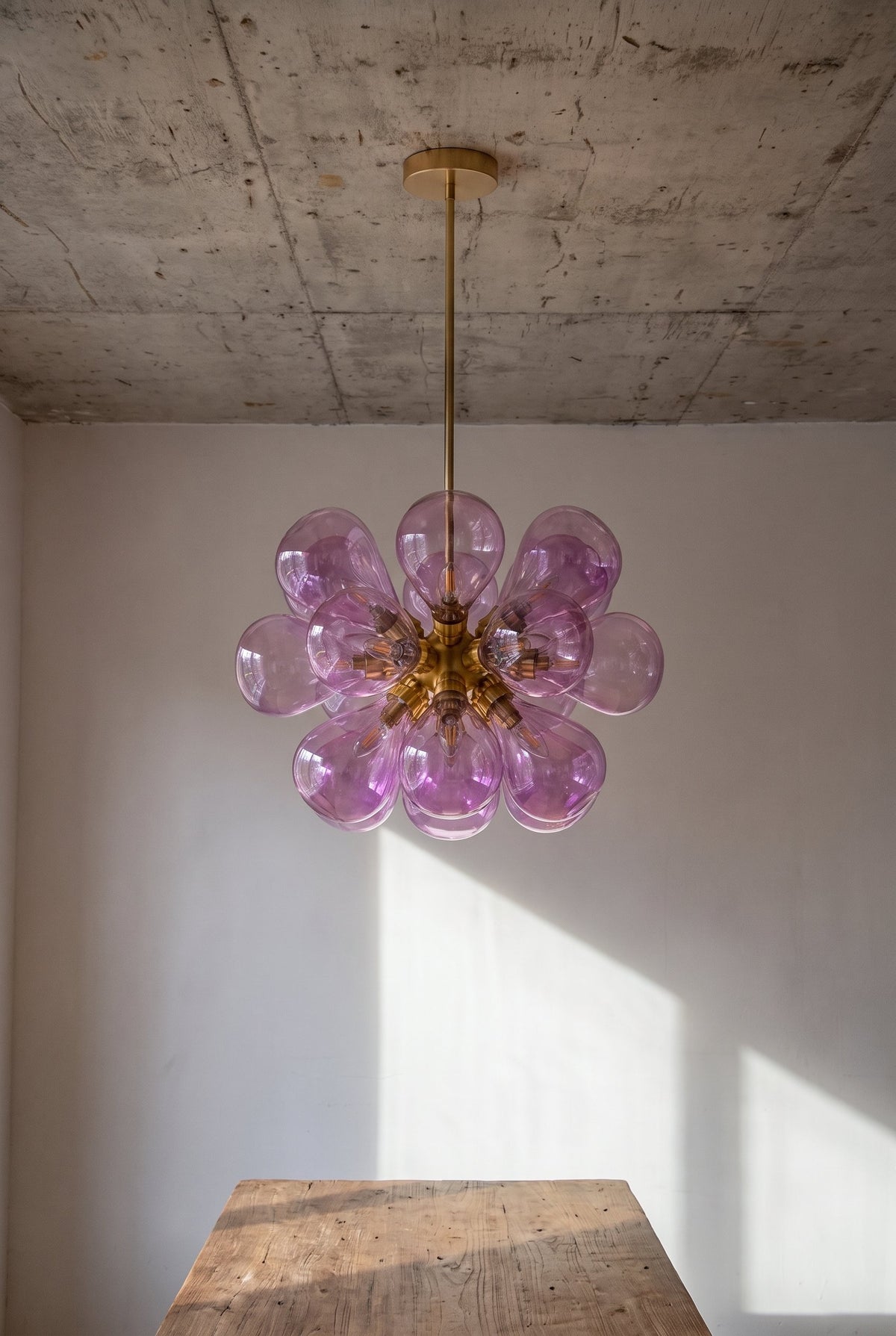 Vue rapprochée des globes en verre rose du lustre, révélant la texture unique et la qualité artisanale du matériau. (142 caractères)